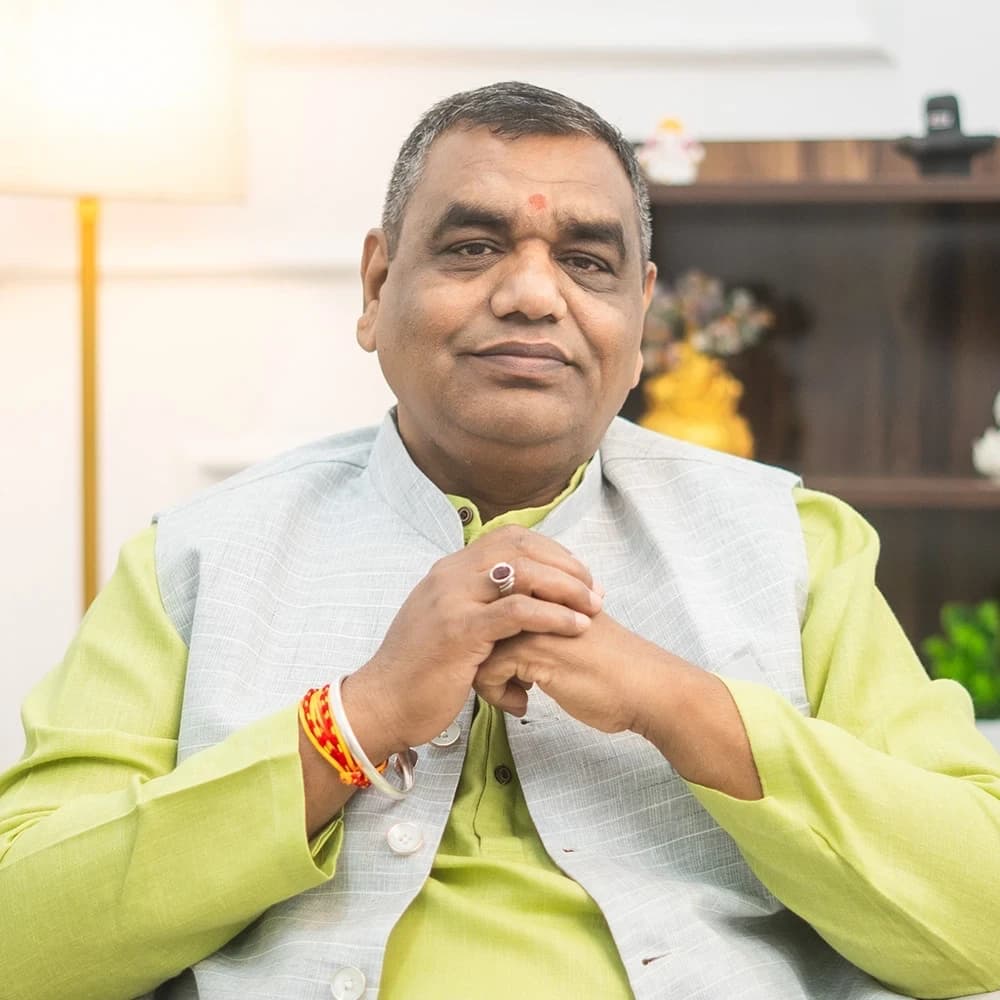 Acharya Chetan Joshi with hands clasped, smiling warmly